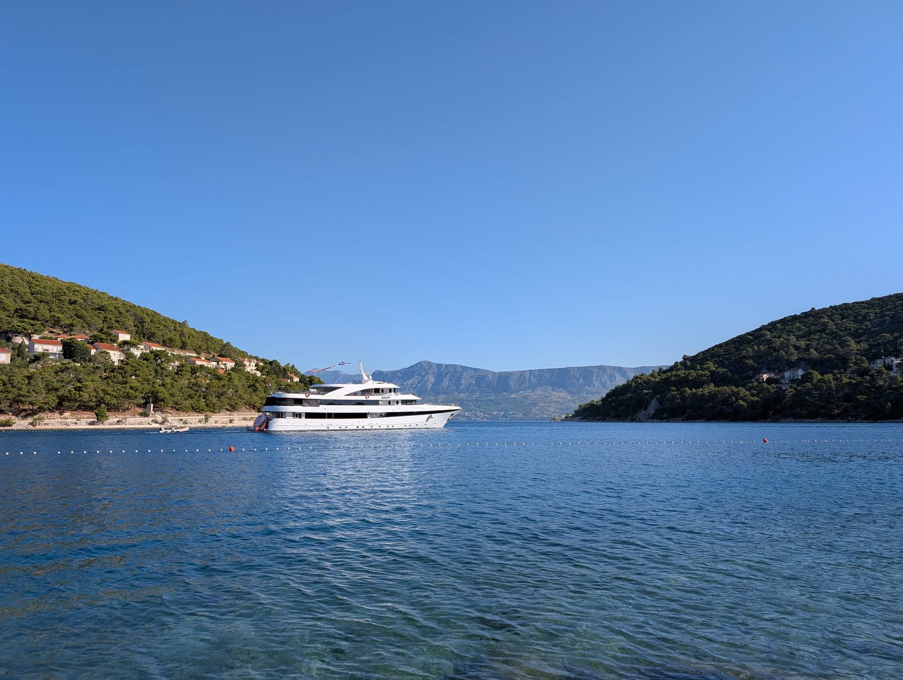 A luxury yacht anchored in a quiet cove on the Croatian coast