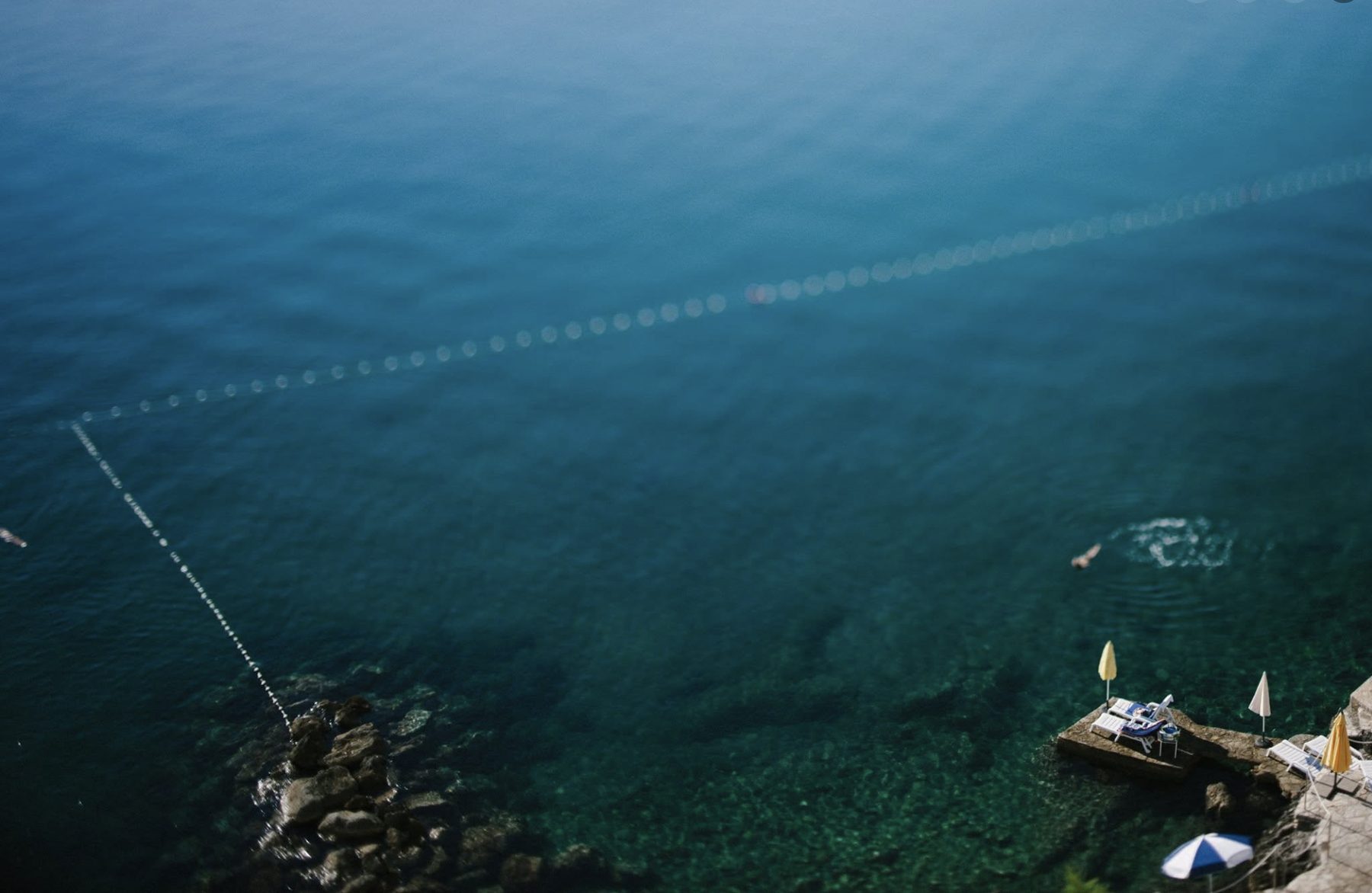 Aerial view of swimmers and a beach club along the Adriatic coast