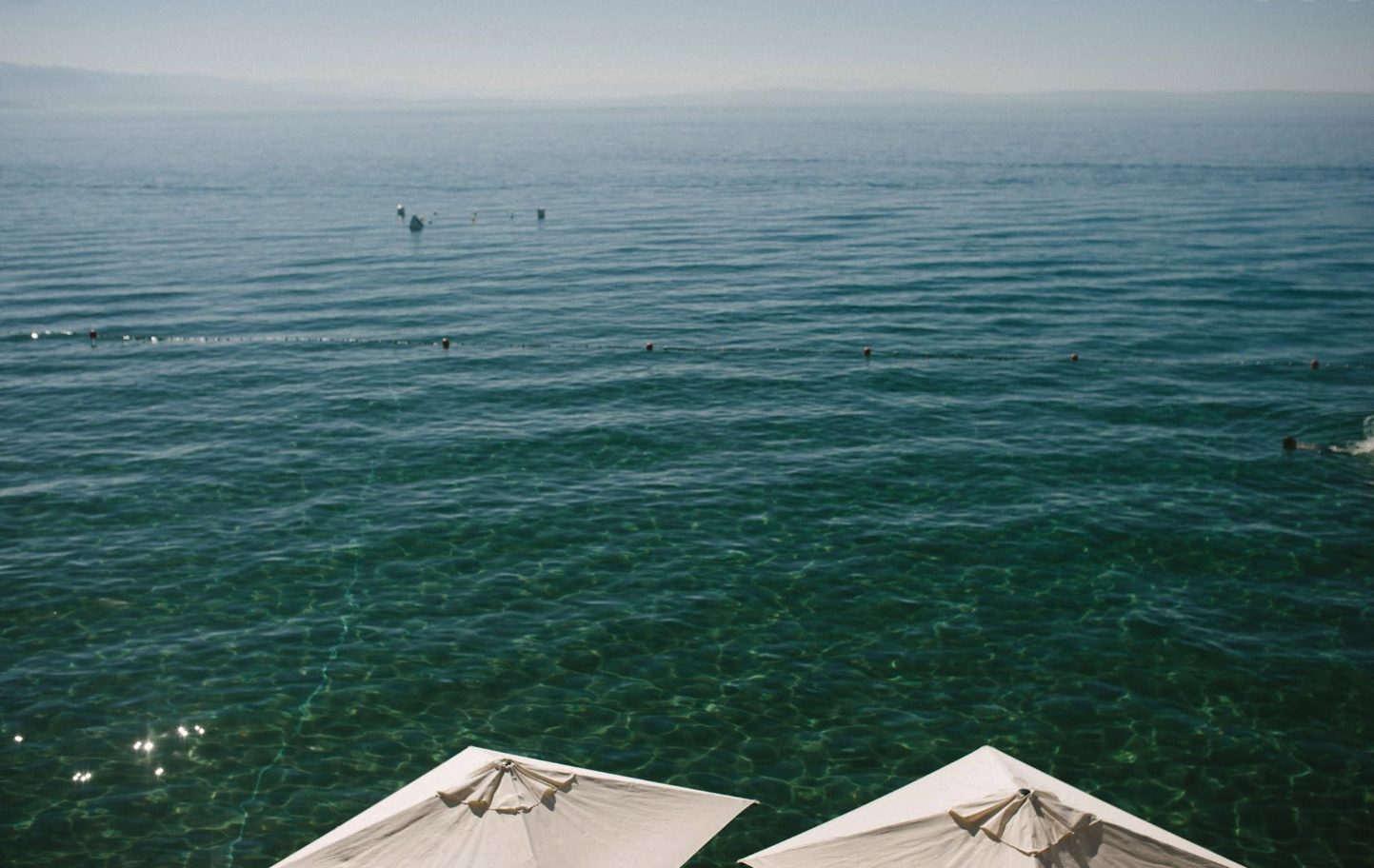 Umbrellas and swimmers at a beach club on the Adriatic