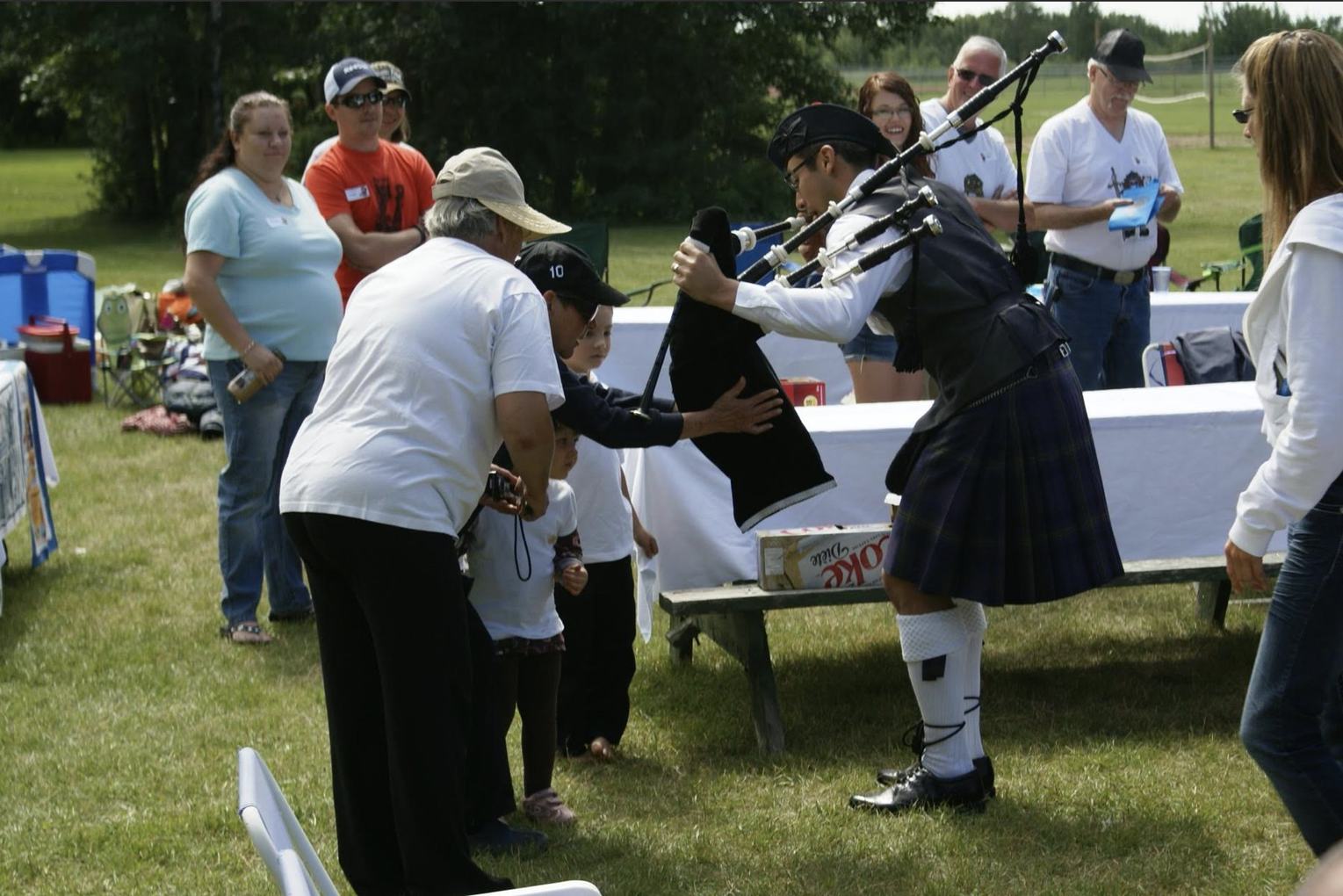 A young guest getting a close look at the bagpipes after a performance