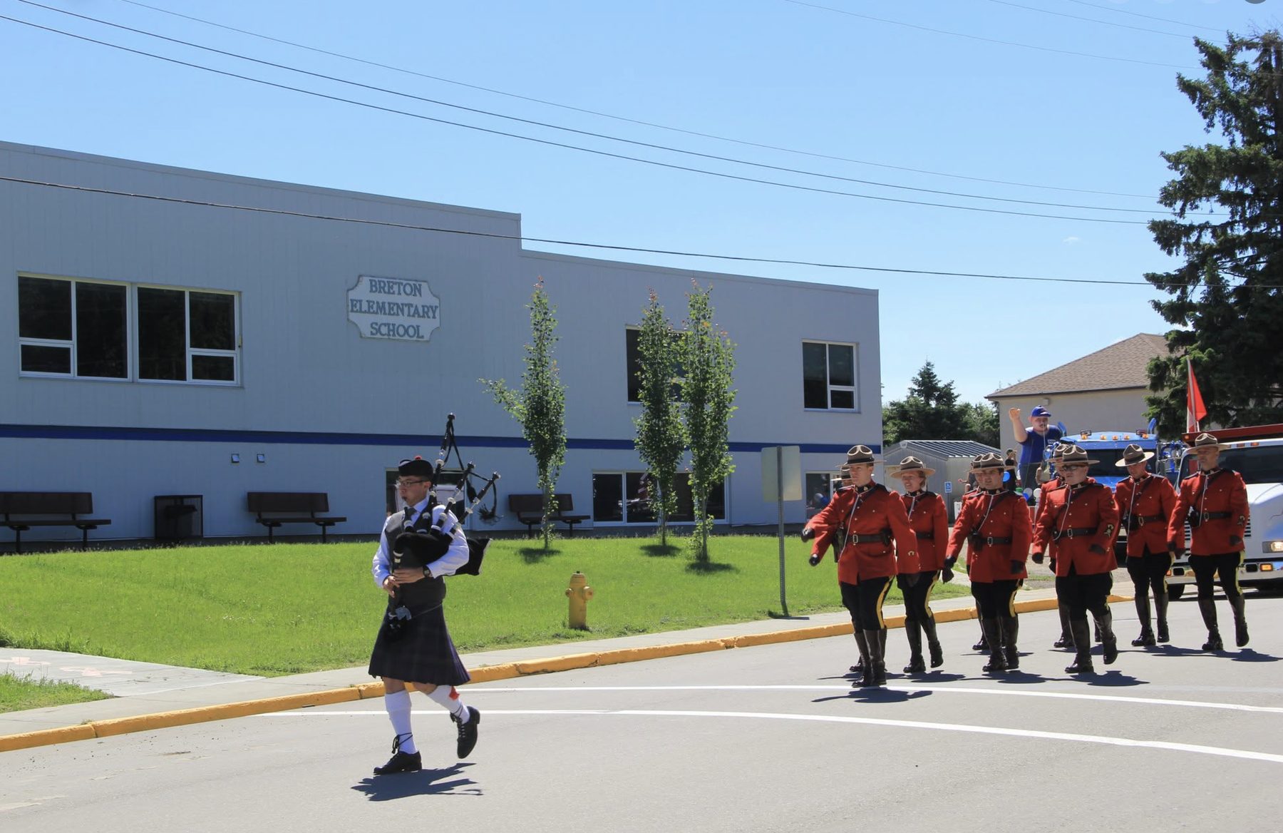 Sean Rathwell piping ahead of RCMP officers past Breton Elementary School