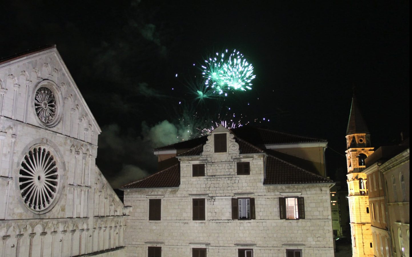 Fireworks over a historic cathedral and bell tower in Zadar, Croatia